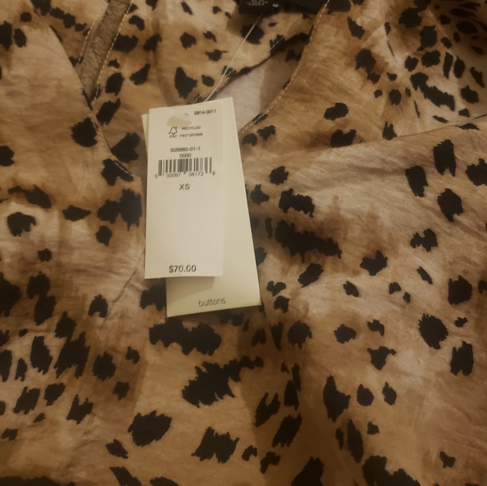 Crew neck with tear drop shaped keyhole. Long sleeves with buttoned cuffs.